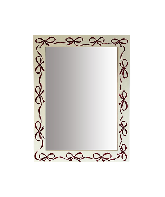 Rectangular mirror with decorative brown bow frame on a white background