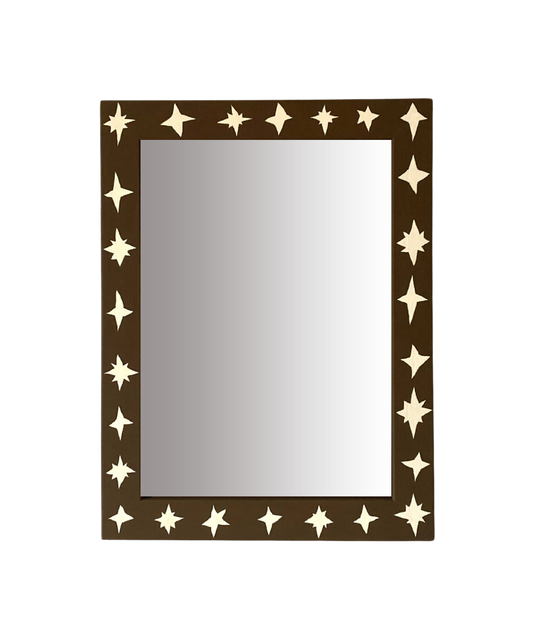 Rectangular mirror with star-shaped cutouts on a brown frame against a white background